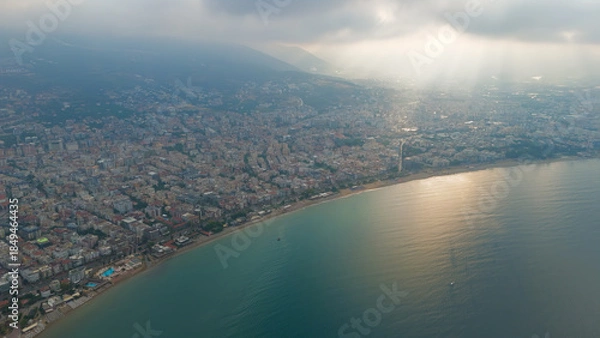 Obraz Alanya, Turkey. Aerial shot of Alanya Lighthouse overlooking Antalya Bay and city beaches with dramatic sunbeams through clouds in summer morning.. Aerial View