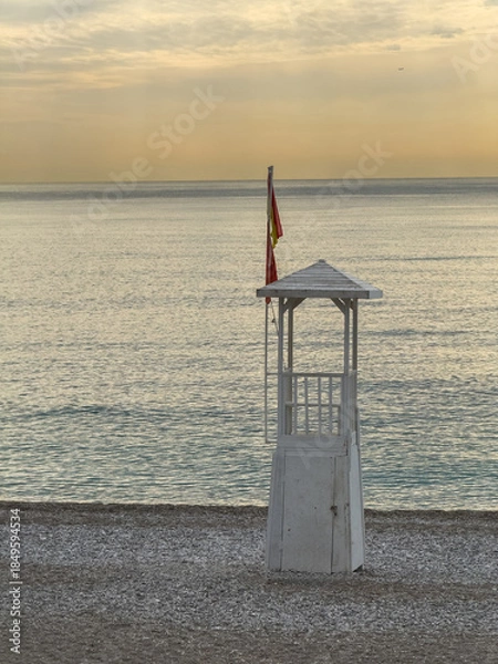 Obraz Quiet Konyaalti beach with lifeguard tower under dramatic sunset sky