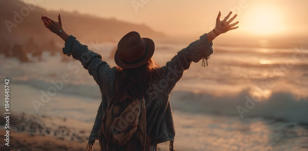 Obraz woman with her arms raised, enjoying the sunset at the beach