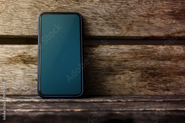 Fototapeta Mobile Phone Mockup Image, Blank Display Screen as Clipping Path, Smart Phone on Old Wooden Desk, Front View