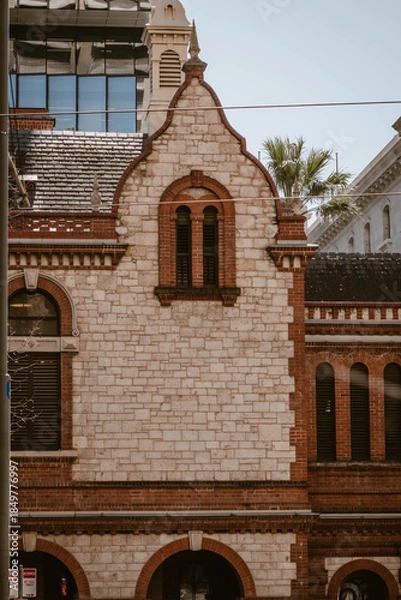 Fototapeta Vertical image of the exterior of a historical building made with bricks outdoor at daytime during springtime season in Adelaide city in Australia.