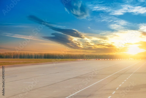 Fototapeta Beautiful evening landscape of runway, airstrip in the airport terminal ready for airplane landing or taking off with dramatic cloudy sunset background. Travel aviation future concept at golden hour.