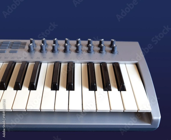 Obraz MIDI Keyboard Controller for Electronic Music Production with many control knobs on dark blue background front view