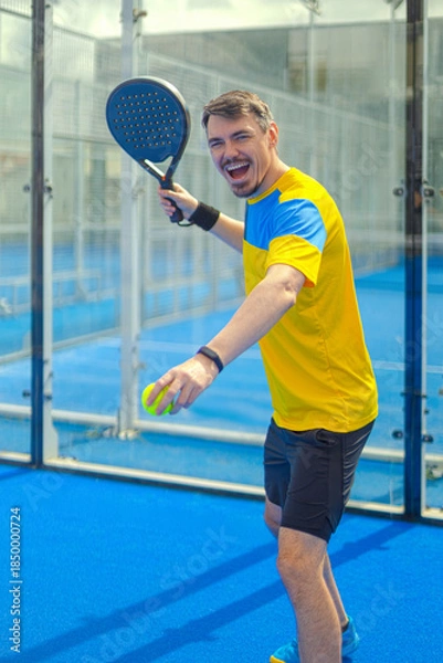 Obraz Family team mx. Group of two mix padel tennis players with racket. Woman and man athletes with paddle racket on the blue court. Sport concept. Download a high quality photo for a sports app.