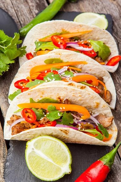 Fototapeta Three mexican tacos with meat and vegetables. Tacos al pastor on