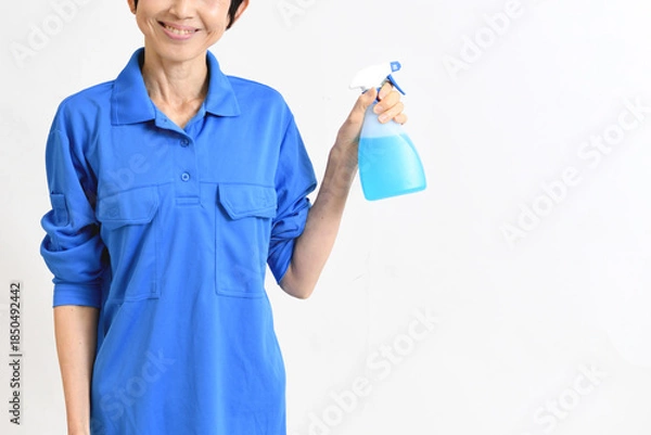 Obraz 清掃用スプレーを持つ作業服のアジア人の中高年女性