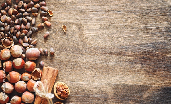 Fototapeta Different nuts on a wooden table. Cedar, cashew, hazelnut, walnu