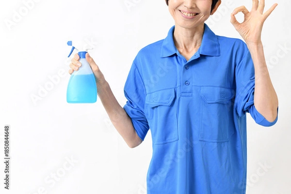 Obraz 清掃用スプレーを持ちOKサインをする作業服のアジア人の中高年女性