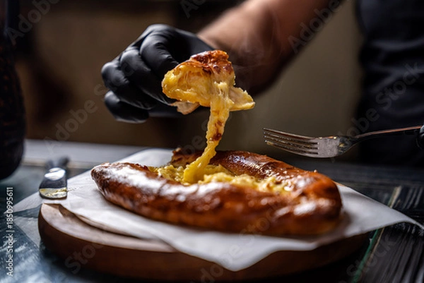Fototapeta Georgian khachapuri cheese bread being pulled apart