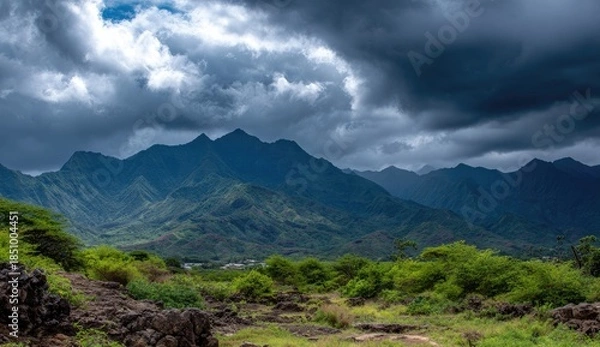 Obraz Jagged green mountains under a dramatic stormy sky.