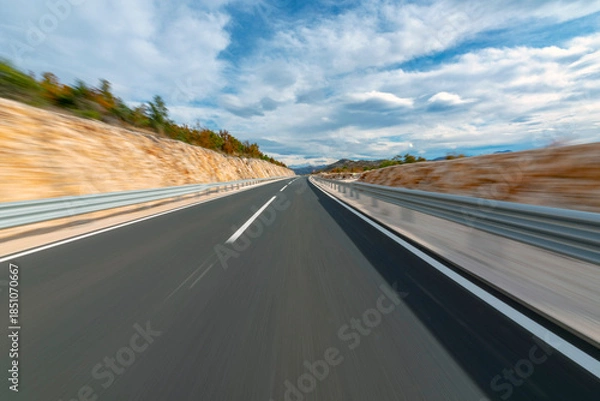 Fototapeta Driving a car at high speed on the open road