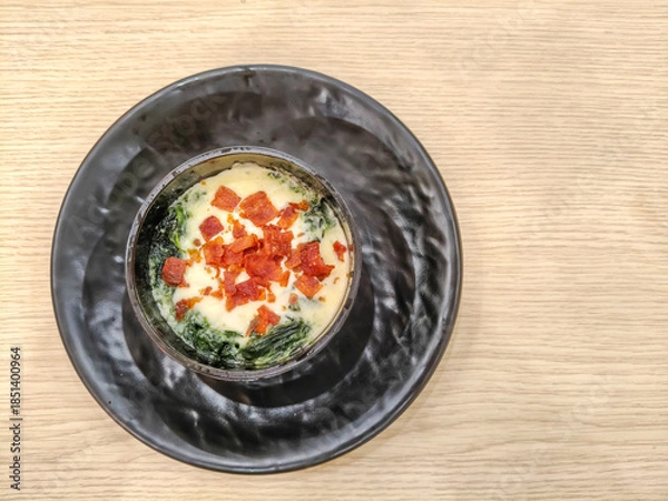 Fototapeta Spinach and cheese lasagna topped with crispy bacon in a cup. Top view