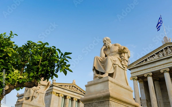Fototapeta Ancient statue of the great Greek philosopher Socrates on background classical columns and the Greek flag. 