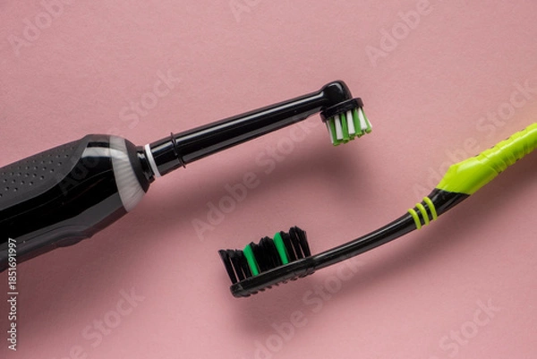 Obraz New electric automatic toothbrush vs manual toothpaste on a pink background.