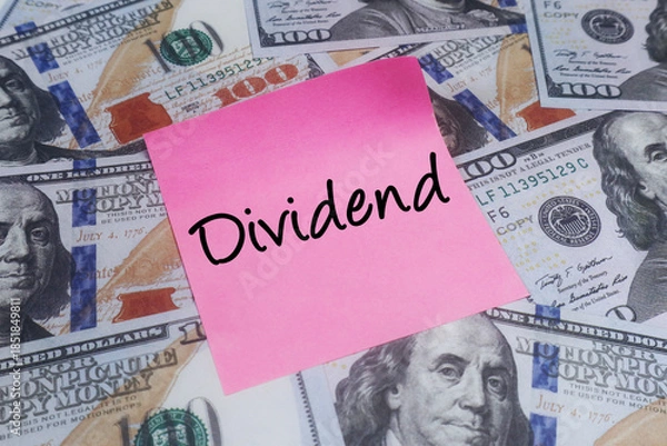Obraz Pink sticky note with DIVIDEND text over US dollar bills. Concept of investment returns and corporate profit.
