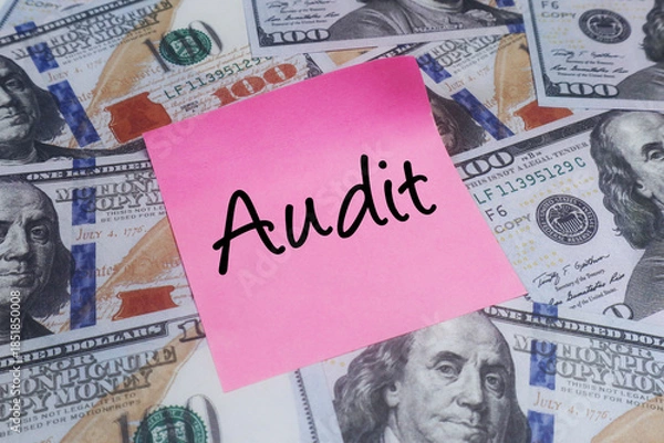 Obraz Pink sticky note with AUDIT text over US dollar bills. Concept of financial inspection, compliance and tax.