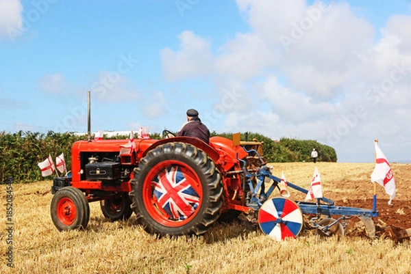 Obraz Vintage tractor ploughing a field	