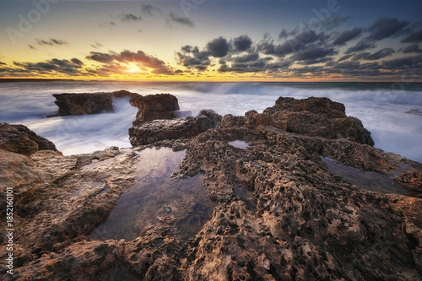 Obraz Sea waves during storm on sunset splash on stones.