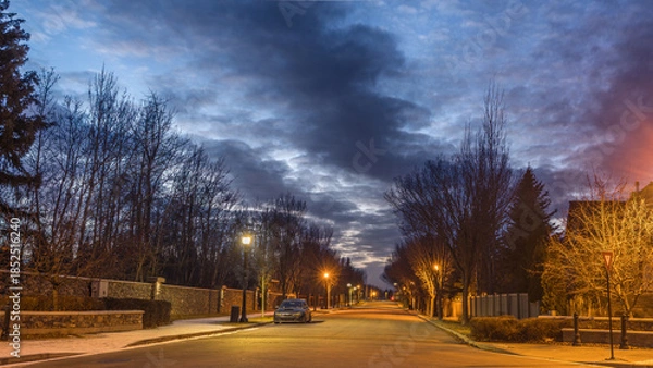 Obraz Cityscape with  with street road night lights on and dark cloud in sky