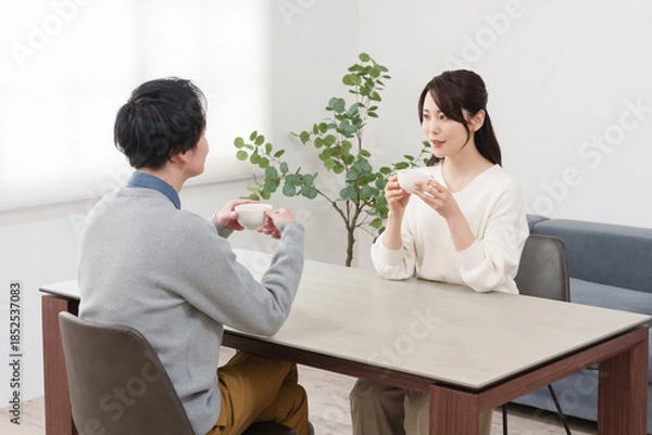 Fototapeta 家で飲み物を飲みながら会話する夫婦