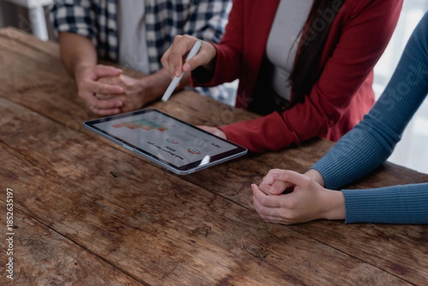 Fototapeta Business colleagues analyzing bar charts on a digital tablet