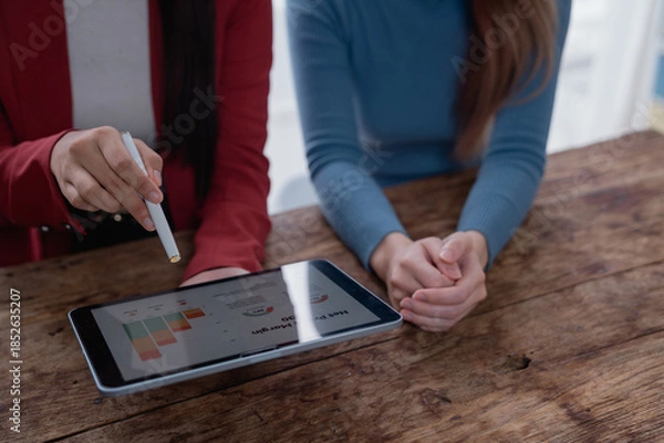 Fototapeta Businesswoman explaining data charts on digital tablet