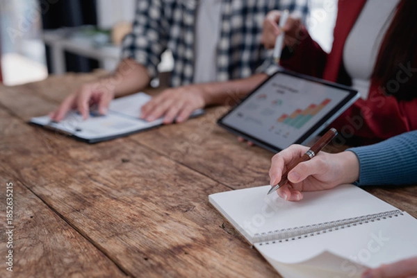 Fototapeta Business professionals collaborating and analyzing data during a meeting