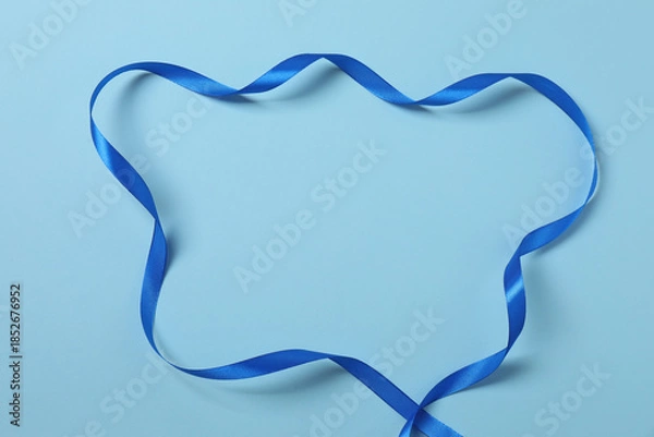 Fototapeta Curled blue ribbon on a colored background
