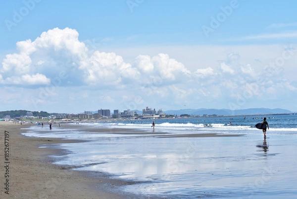 Obraz 潮が引いた片瀬西浜海岸で海に入るサーファー