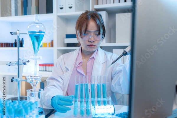 Obraz A chemistry researcher in a laboratory surrounded by scientific equipment and test tubes, representing innovation, scientific development, and modern medical research environment.