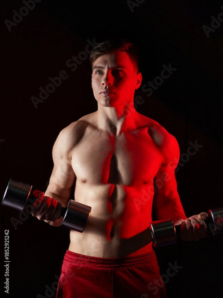 Fototapeta Young man training with dumbbells