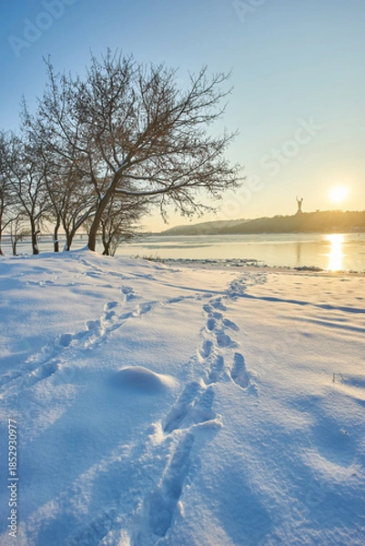 Obraz Sunny winter landscape with footprints and distant monument.