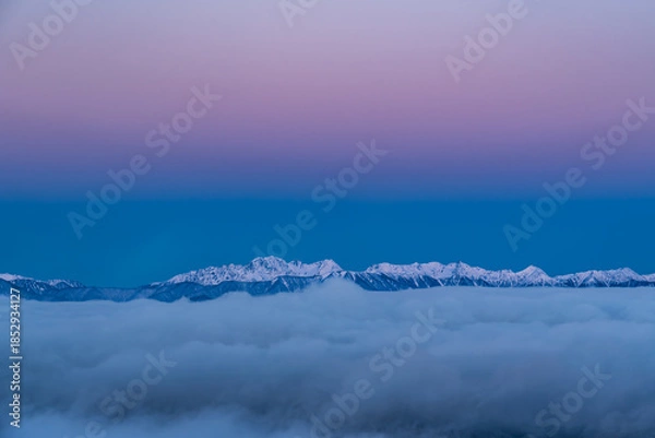 Obraz 霧ケ峰高原車山山頂から雲海に浮かぶ北アルプス穂高連峰をピンクに染めるビーナスベルトとモルゲンロート