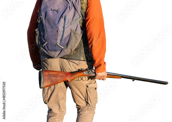 Fototapeta A hunter with a gun in camouflage clothing. A gentleman with a gun, medium shot, unrecognizable.