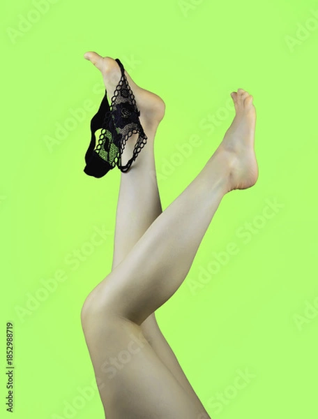 Obraz Artistic portrait of female legs raised with lace underwear on ankle creating minimalist sensual fashion concept and elegant body shape