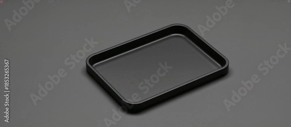 Obraz Black rectangular tray on a dark background for serving or storage with large copy space