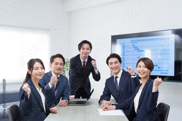 Fototapeta オフィスで会議するビジネスマン男女のガッツポーズ
