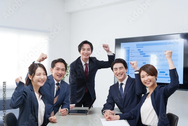 Fototapeta オフィスで会議するビジネスマン男女のガッツポーズ