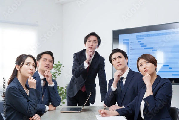 Fototapeta オフィスで会議するビジネスマン男女が考える