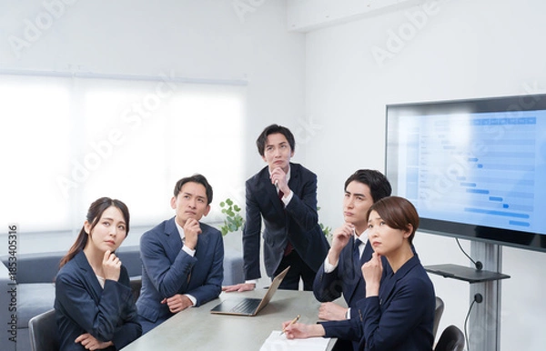 Fototapeta オフィスで会議するビジネスマン男女が考える