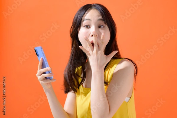 Obraz スマホを持って驚く女性
