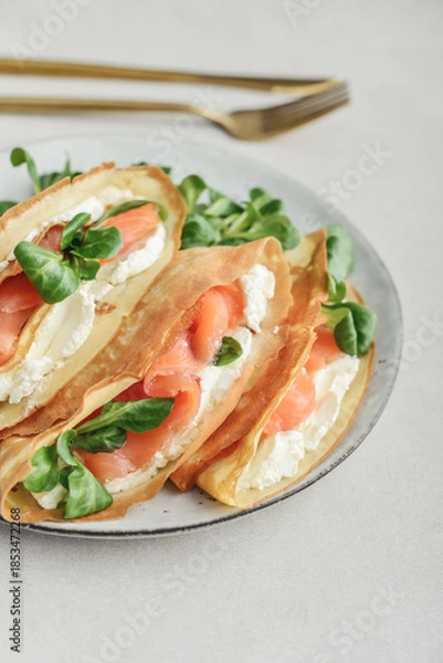 Obraz Crepes or thin pancakes with lightly salted salmon, soft cheese and cornsalad