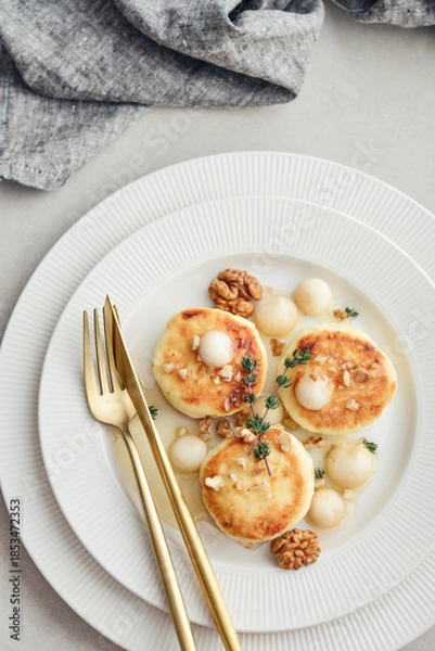 Obraz cottage cheese pancakes, syrniki, curd fritters served with pear balls, walnut and honey