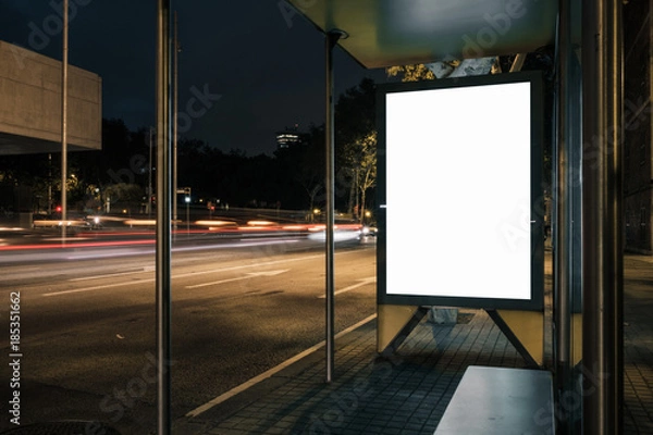 Fototapeta Advertisement light box mock-up at a bus stop at night. Marketing design.