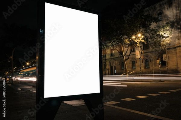 Fototapeta Blank advertisement lightbox in the street at night. Display mock-up. Business banner.