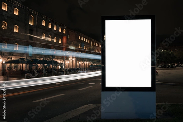 Fototapeta Blank white advertisement lightbox in at night. Mock-up design. Colourful car light lines.