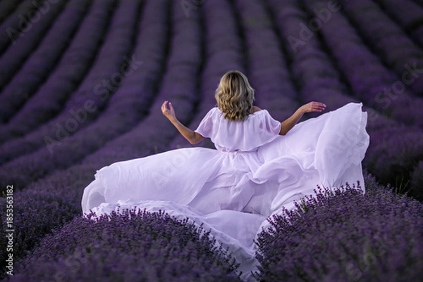 Fototapeta Lavender Fields Provence Woman WhiteDress: Summer photoshoot showcasing a woman in a white dress amidst purple lavender fields in Provence, France.
