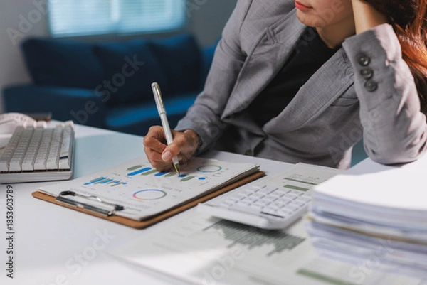 Fototapeta Businesswoman analyzing financial data working late at night
