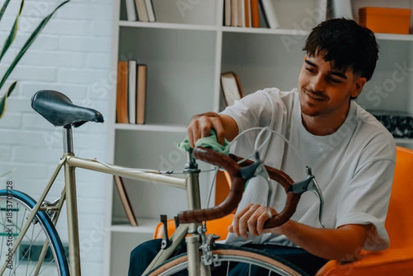 Obraz young man cleaning or preparing vintage bicycle