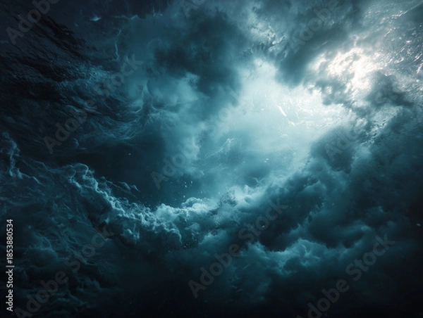 Obraz Dramatic ocean waves crashing under stormy sky with sunlight filtering through.